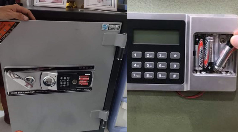 Bên trái két xám có tay gạt và bàn phím nhỏ, bên phải bàn phím màn hình LCD cạnh hộp pin mở lộ pin AA