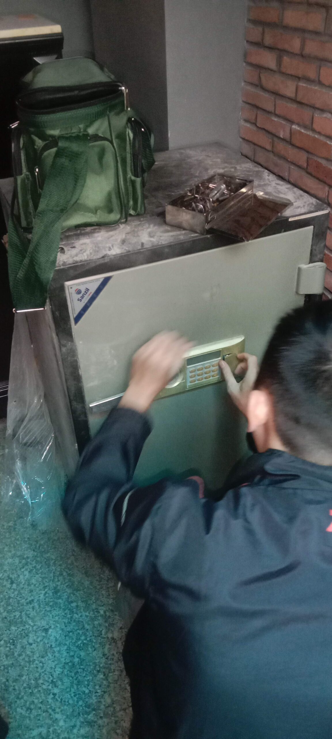 Thợ kéo cửa két nhỏ màu xanh đặt trong góc phòng hẹp